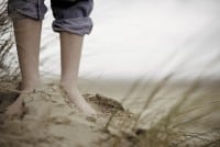 Boy Standing Barefoot in Sand