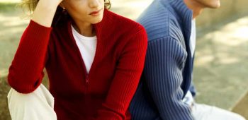 Young Couple Seated Back To Back